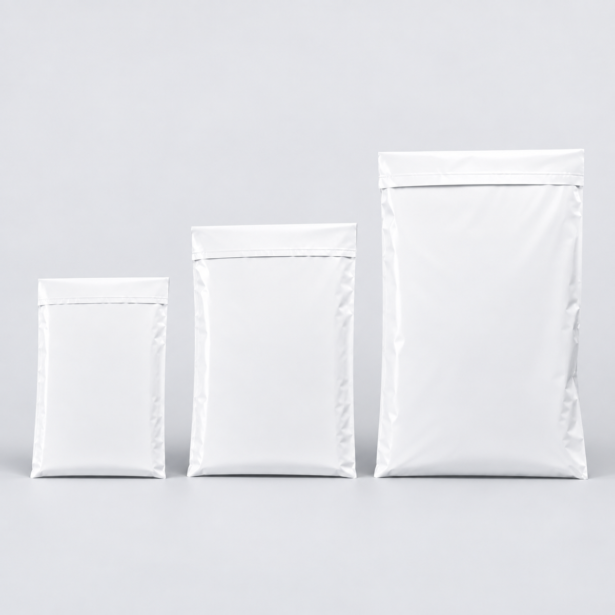 Small, medium and large white mailing satchels shown side by side